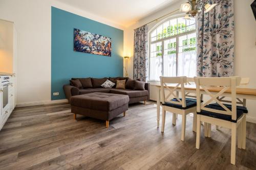 Albizia-Apartments في بادن: غرفة معيشة مع أريكة وطاولة