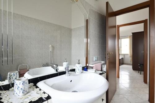 y baño con lavabo blanco grande y bañera. en casa vacanza Luciano, en Tortolì