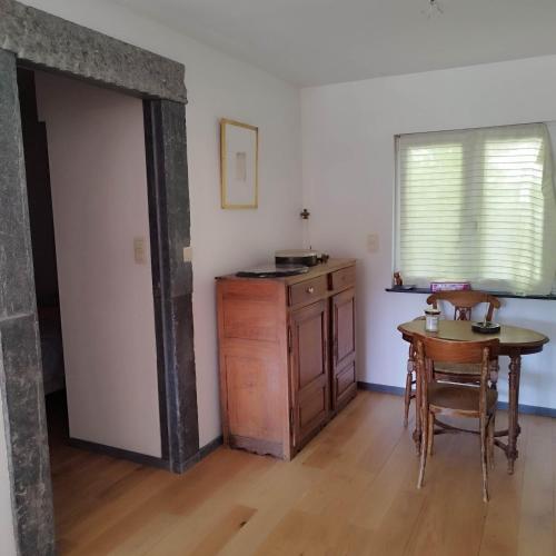 a room with a table and a kitchen with a window at le chalet des remparts in Aywaille