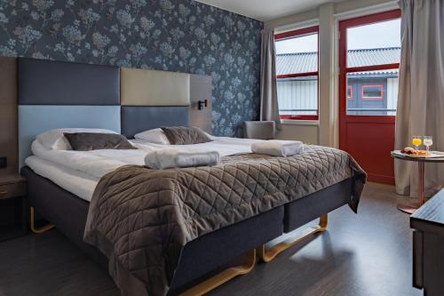 a bedroom with a large bed in a room at Milepelen Hotel & Vertshus in Sand