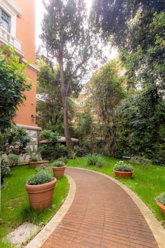 a brick walkway in a garden with potted plants at Mangili Garden Hotel in Rome