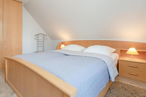 um quarto com uma cama grande e um cobertor azul em Fahrenkrug Wohnung 1 em Scharbeutz