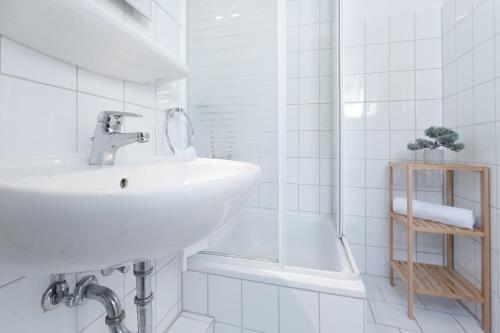 uma casa de banho branca com um lavatório e um chuveiro em Fahrenkrug Wohnung 1 em Scharbeutz