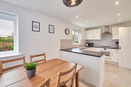 a kitchen and dining room with a wooden table at Host & Stay - Cayton Bay Cottage in Cayton