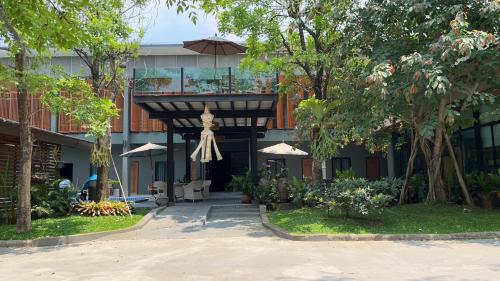 a building with a porch with an umbrella at Look at Home Lamphun in Lamphun