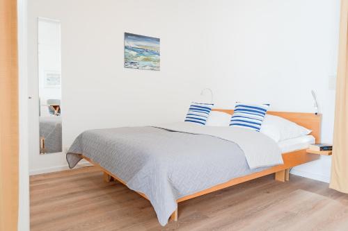 1 dormitorio con 1 cama con almohadas azules y blancas en Am Hang 13 Wohnung 18, en Scharbeutz