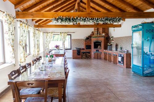 ein Esszimmer mit einem langen Tisch und einer Küche in der Unterkunft Casa Mariteo Colibita in Colibiţa