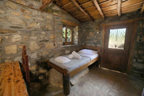 a bedroom with a bed and a window and a wooden door at Captain Ikaros in Agios Kirykos