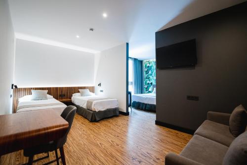 a hotel room with two beds and a couch at Málaga Premium Hotel in Málaga
