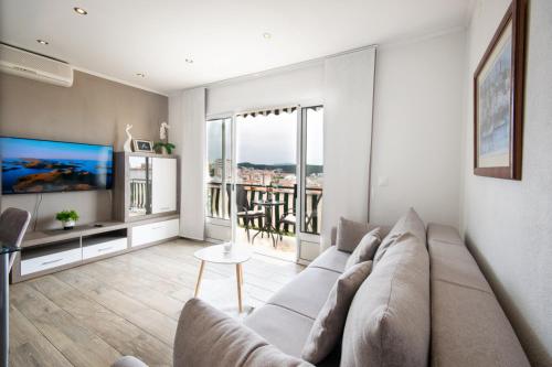 uma sala de estar com um sofá e uma televisão em Apartments Villa Luce em Makarska
