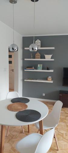 a dining room with a white table and chairs at Apartament Rodzinny Przy AquaParku in Reda