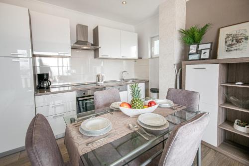 a kitchen with a table with a bowl of fruit on it at Apartments Villa Luce in Makarska