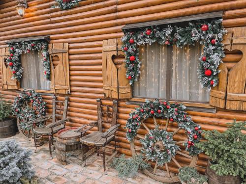 a wooden house with christmas wreaths on the windows at Casa Rustic 2 in Malo Središte