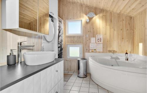ロンストラップにあるStunning Home In Hjrring With Saunaのバスルーム(大きな白いバスタブ、シンク付)