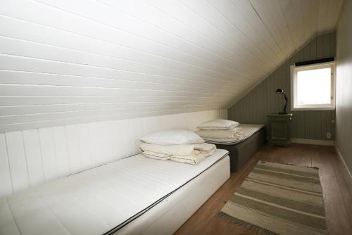 2 Betten in einem kleinen Zimmer mit Fenster in der Unterkunft Spacious house in Hjo by Vattern with fantastic views in Tidaholm