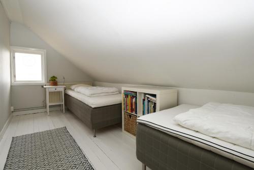 1 dormitorio con 2 camas y estante para libros en Spacious house in Hjo by Vattern with fantastic views en Tidaholm