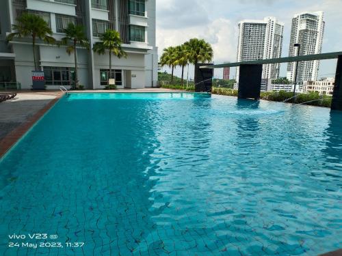 a large blue swimming pool in a building with tall buildings at Peace home09 in Cyberjaya