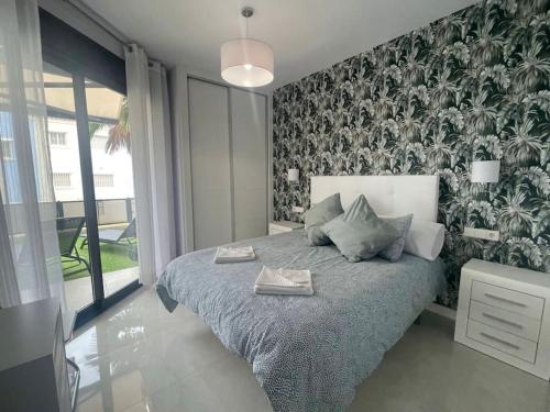 - une chambre avec un lit et un mur orné de plantes dans l'établissement 2 bedroom infinity beach., à Mazarrón