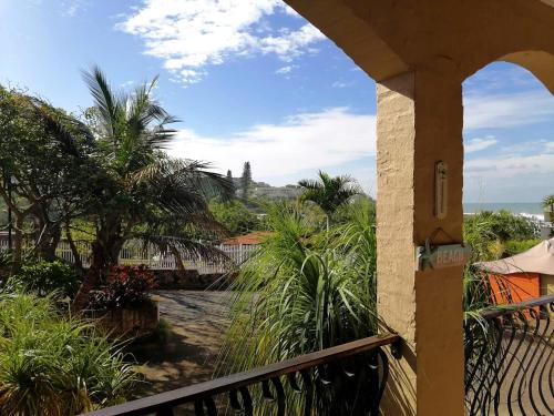 a balcony with a view of the ocean and palm trees at Crayfish Inn No.4 in Ramsgate