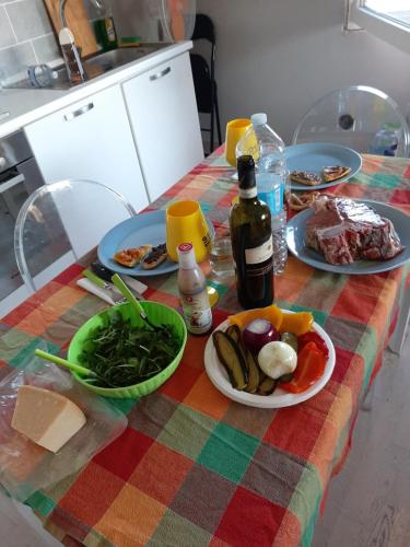 - une table avec des assiettes de nourriture et une bouteille de vin dans l'établissement Civico 25, Carcioni - Belgirate, à Belgirate