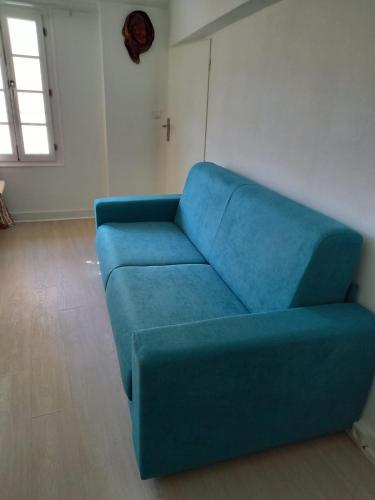 a blue couch sitting in a living room at Comfortable and welcoming apartment in Avignon in Avignon