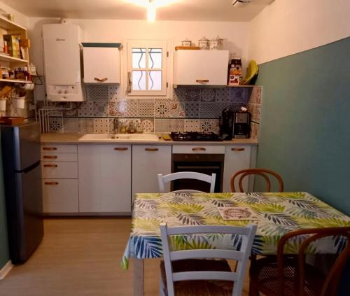 a kitchen with a table and chairs and a kitchen with white cabinets at Comfortable and welcoming apartment in Avignon in Avignon