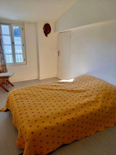 a bedroom with a large bed with an orange bedspread at Comfortable and welcoming apartment in Avignon in Avignon