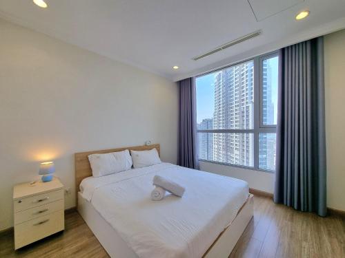 - une chambre avec un lit blanc et une grande fenêtre dans l'établissement 123 Apartment in Vinhomes Central Park - Landmark 81, à Hô-Chi-Minh-Ville