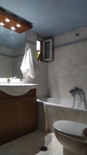a bathroom with a sink and a tub and a toilet at Corinas Holiday House in Chania