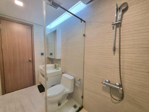 胡志明市的住宿－123 Apartment in Vinhomes Central Park - Landmark 81，一间带卫生间和玻璃淋浴间的浴室