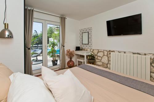 een slaapkamer met een bed en een tv aan de muur bij Casa Benita in Hvar