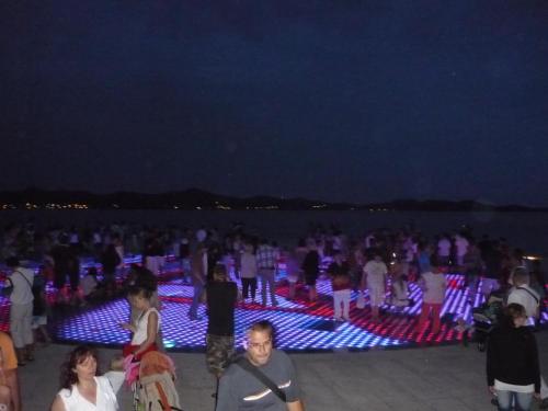 a crowd of people standing on the beach at night at Apartment Seline in Seline