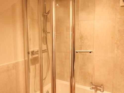 a shower with a glass door in a bathroom at The Barn in Plymouth