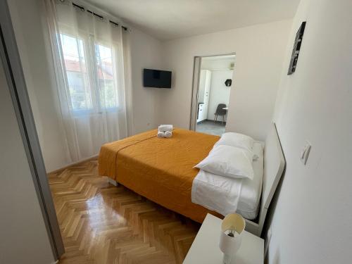 Dormitorio pequeño con cama y mesa en Apartments Roko, en Turanj