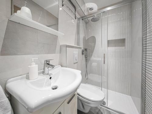 a white bathroom with a sink and a toilet at Apartments Villa Luce in Makarska