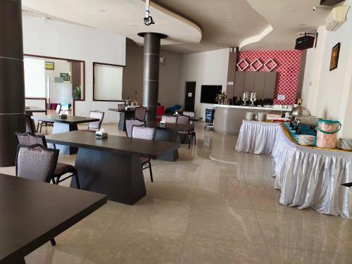 un restaurante con mesas y sillas en una habitación en OS Hotel Tanjung Uncang, en Sagulung