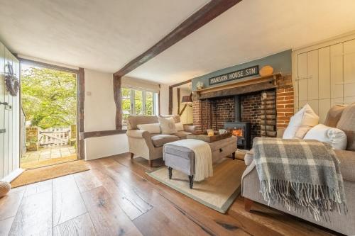 a living room with a fireplace and a couch at Well Green Cottage in Wenhaston