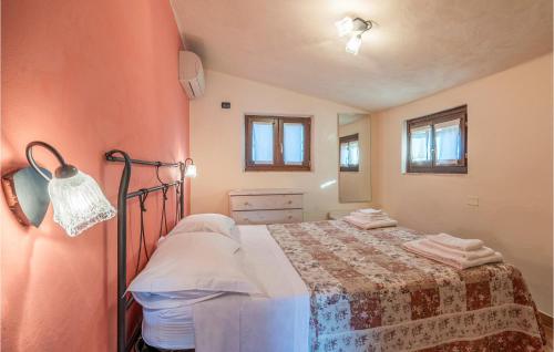 um pequeno quarto com uma cama com um cobertor em 2 Bedroom Pet Friendly Home In San Giovanni em Montefiore dellʼAso
