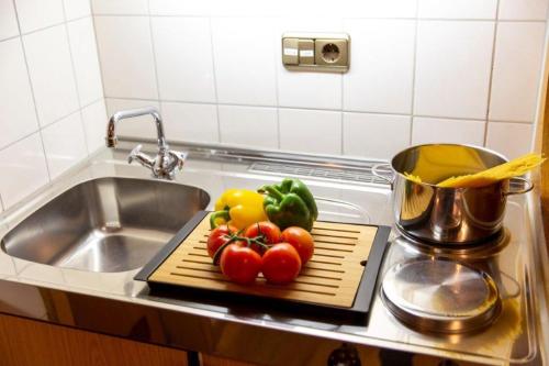 a cutting board with tomatoes on a counter next to a sink at Landhaus Menz in Oberstdorf