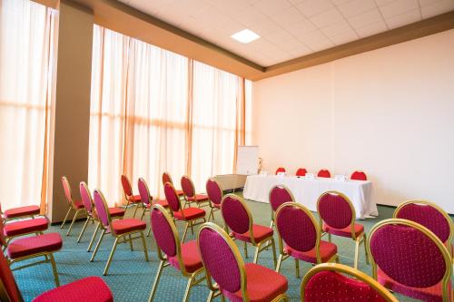 a room with red chairs and a table in it at Bacolux Afrodita, Herculane in Băile Herculane