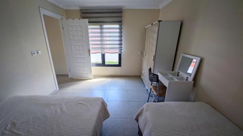 a bedroom with two beds and a sink and a mirror at HAPPY LİFE HOUSES in Ürkmez