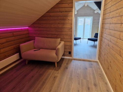 a living room with a chair and a mirror at Andøy Vest Rorbuer Reine in Reine