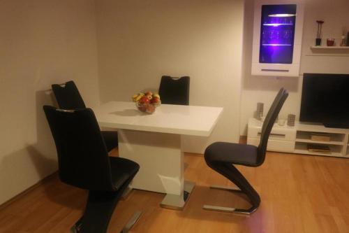 una mesa blanca y sillas en una habitación con TV en Kölner Pension Apartments, en Colonia