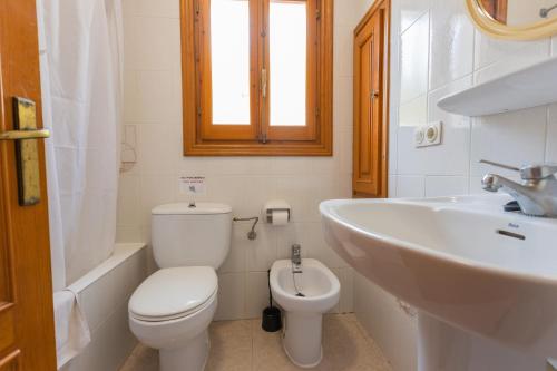a bathroom with a white toilet and a sink at Villa Loes in Son Bou