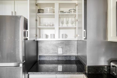 eine Küche mit weißen Schränken und einer schwarzen Arbeitsplatte in der Unterkunft Ballston 1BR w gym pool near Restaurants WDC-601 in Arlington