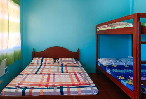 a bedroom with two bunk beds and a blue wall at Sunset Beach and Family Resort Gonzaga Cagayan in Bawa