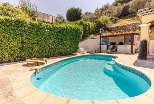 einen Pool in einem Hof mit Hecke in der Unterkunft Maison provençale familiale au calme avec piscine in Chateauneuf Villevieille