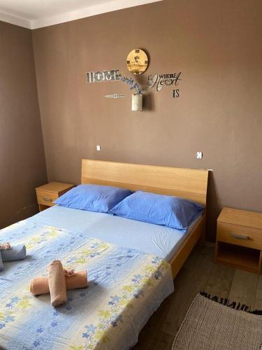 a bedroom with a bed with blue sheets and a clock on the wall at Island paradise Lavdara in Sali