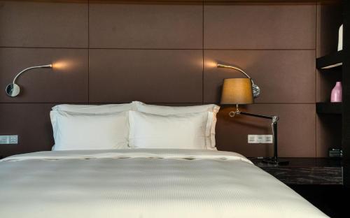 a bedroom with a large bed with two lamps on it at Shenzhen O Hotel in Shenzhen