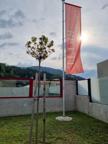 a tree and a flag on top of a building at Gästehaus Rettl in Lavamünd